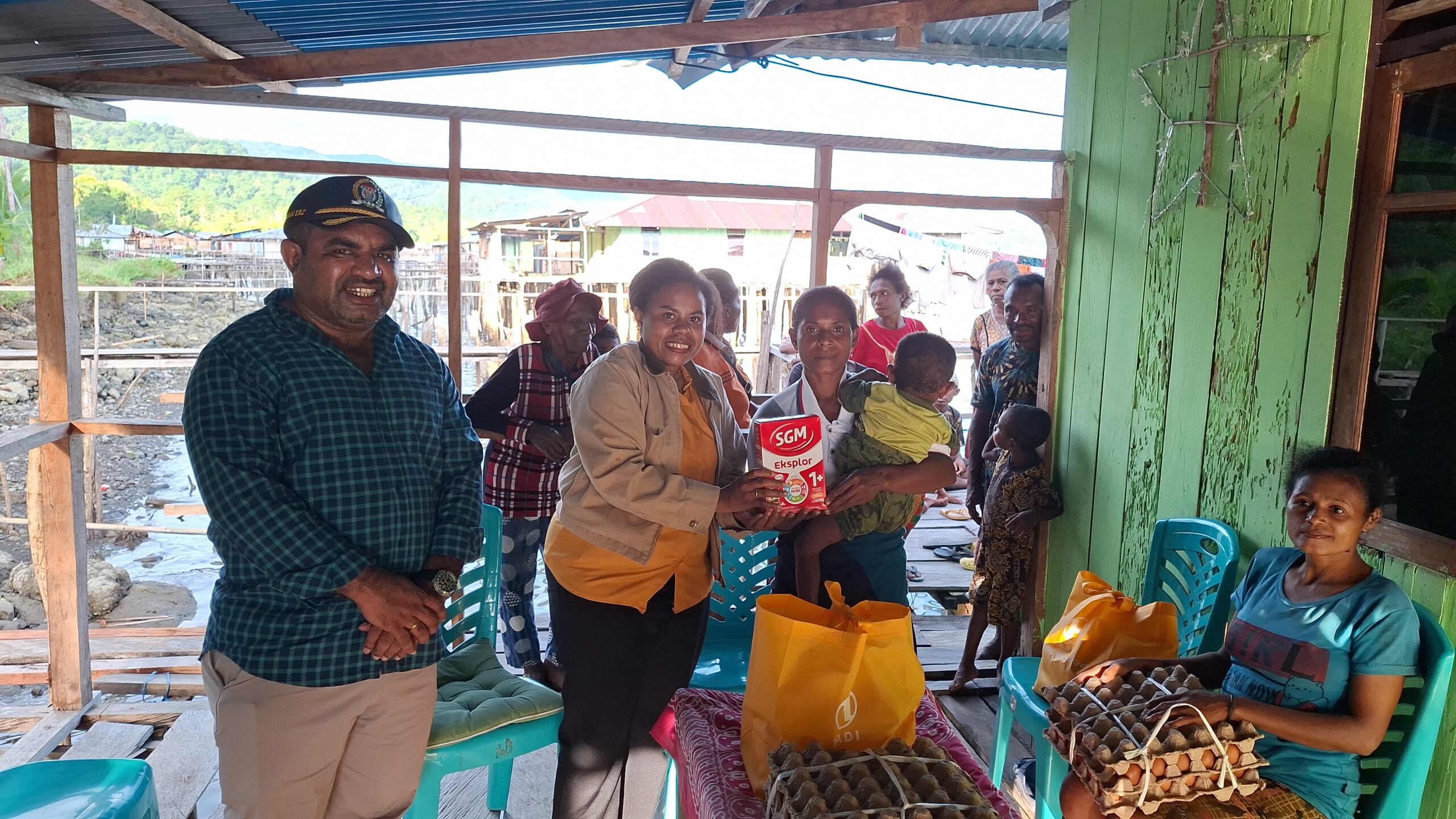 Ketua DPRK Kepulauan Yapen, Ebzon Y. Sembai, bersama istri, Adomina Elisabet Maniani, menyerahkan bantuan pemenuhan gizi kepada ibu hamil dan ibu menyusui saat pelaksanaan Program Orang Tua Asuh di Kampung Papuma, Distrik Yapen Barat, Selasa (7/7/2026). Program tersebut merupakan bagian dari upaya percepatan penurunan angka stunting di Kabupaten Kepulauan Yapen. (Foto: Humas/TerasWeisiho.com)